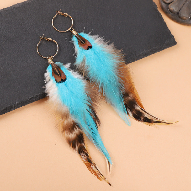 Long feather earrings in peacock blue